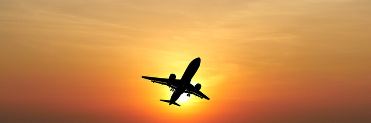 Soaring Silhouette: An aircraft takes flight against a striking backdrop of a sunset, symbolizing journeys, destinations and travel.