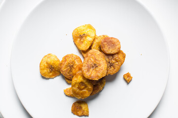 Overhead view of fried plantains on a white countertop, top view of fried ripe plantains on a white background