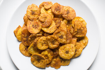 Overhead view of fried plantains on a white countertop, top view of fried ripe plantains on a white background