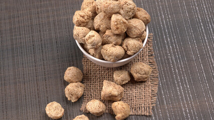 Raw soya chunks on dark background. Healthy, nutritious soybean meat, chunks isolated.Vegan food...