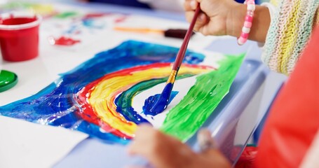 Kindergarten, hands and kid with painting for education, creativity and skills development. Preschool, drawing and child as student for rainbow project, learning or motor growth in closeup with brush