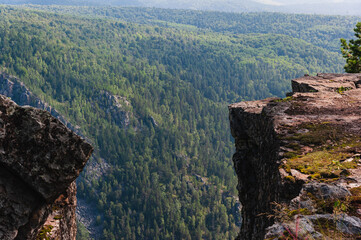 Panorama of forest on hills between two rocks.