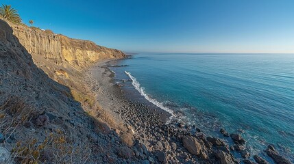 Coastal cliffs meet the ocean.  Rocky shore with gentle waves
