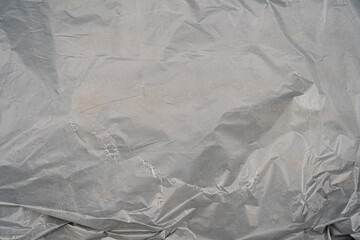 Textured gray surface with crinkled pattern and subtle variations.