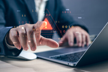 Concept of warning or alert, notification, technology crime,businessman hand working on laptop touching warning about access to software, virus,dangerous cyber attack or online network hacking threat