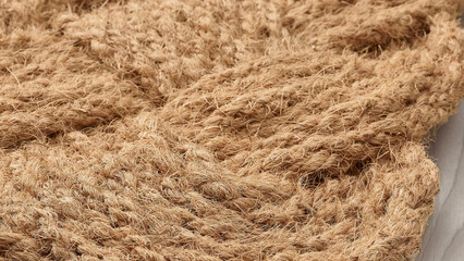 Natural jute fabric texture showcasing intricate weaving patterns in a warm, light environment.
