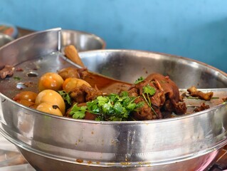 Tantalizing Bowl of Spicy Stew with Tender Meat, Fresh Herbs, and Boiled Eggs in Vibrant Setting