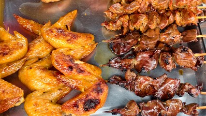 Delicious and Flavorful Grilled Chicken Wings and Skewers on a Metal Platter Ready to Serve