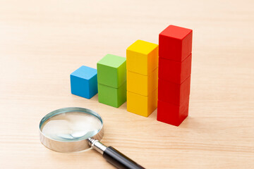 積木で作られたグラフと虫眼鏡