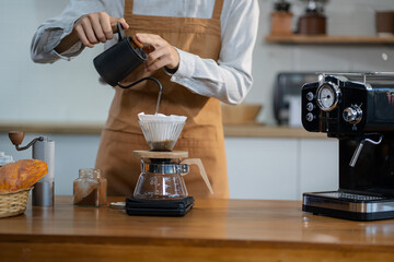 Young barista making coffee, coffee preparation service concept.