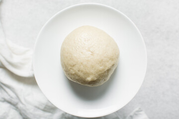 Overhead view of steamed bun on a white plate, top view of mantou on a white background, process of making steamed milk buns	