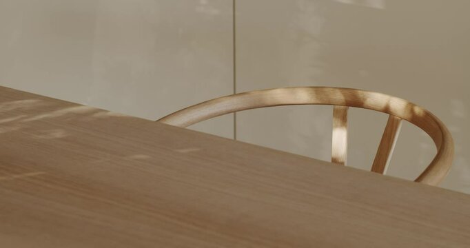 Sunlight streams through a window, casting playful shadows on a modern wooden table and the curved back of a matching chair. interior design, furniture, or lifestyle projects.
