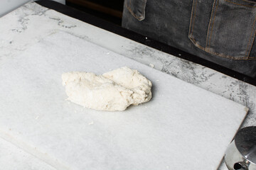 Overhead view of steamed bun dough being kneaded on a white background, top view of mantou dough being mixed, process of making steamed buns