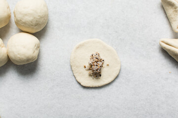 Overhead view of sugar steamed buns being made over a marble countertop, process of making sugar filled steamed buns or mantou