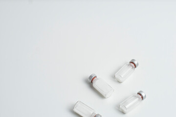 Flatlay of vaccine vial bottles with copy text space on white background. Flatlay of vaccine vials with white background, health medical concept.