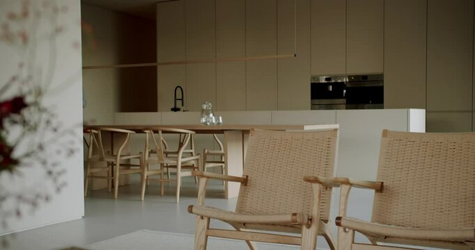 Modern, minimalist kitchen with wooden furniture and neutral colors. The open-plan design creates a sense of spaciousness and calm. Natural light illuminates the interior. simple stylish lifestyle.