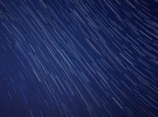 Long exposure star trails in night sky creating streaks of light on deep blue celestial background
