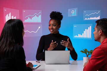 Diverse business team in a meeting, Black businesswoman presenting and gesturing while discussing data with colleagues looking at laptop screen, digital graph interface tech