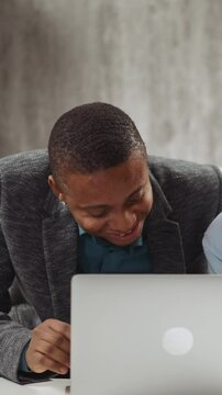 Positive boy pupil watches funny video via laptop and laughs understanding meaning with native speaker English teacher help at home private tuition slow motion