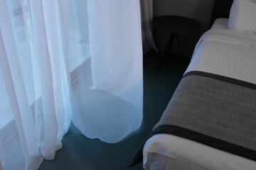 A minimalist comfortable ready elegant inviting hotel room, open window, light wind