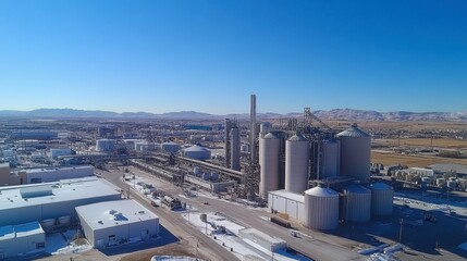 View of grain silos and agricultural processing facility under blue sky.