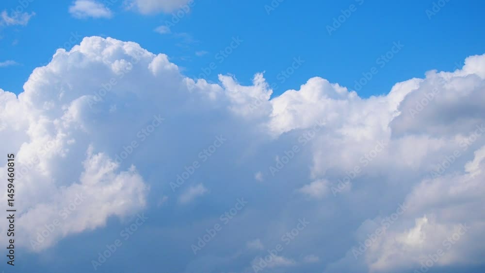 Poster During a serene evening, fluffy clouds leisurely float across the vibrant blue sky, illuminated by the warm glow of the setting sun, evoking a sense of wonder and tranquility