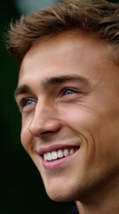 Fototapeta premium Attractive young man smiles with genuine joy happy expression and light brown hair close up portrait of positive attitude and youthful energy