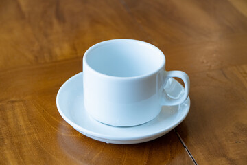 White ceramic coffee cup on wooden table, Minimalist empty mug with saucer