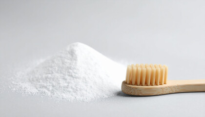 Wooden toothbrush and heap of baking soda on light background. Close-up.