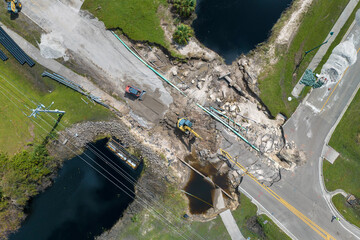 Reconstruction of damaged road bridge destroyed by river after flood water washed away asphalt....