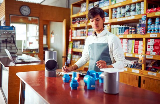 Salesman taking inventory of plumbing pipes and fittings in hardware store