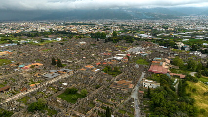 Aerial view of the ruins and remains in the archaeological park of Pompeii, located in the province of Naples, Campania, Italy. It was an ancient Roman town. In background there is the modern city.
