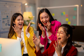 Three women are laughing and clapping in a room