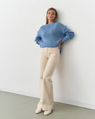 Fashionable female model exuding elegance in a studio setting with a casual pose