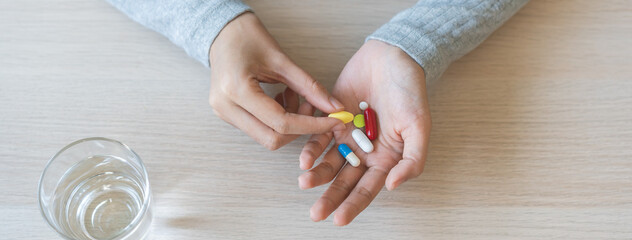 Sick, ill asian young woman, girl hand holding pill capsule, painkiller medicine from stomach pain,...