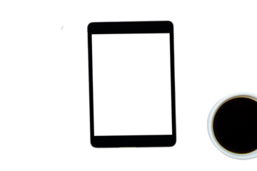 Top view of a tablet with white screen next to a cup of coffee, cut out white background