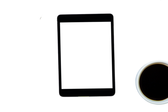 Top view of a tablet with white screen next to a cup of coffee, cut out white background