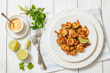 Grilled shrimp on a white plate with lime
