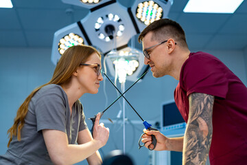 Medics in playful duel. Two healthcare workers face off with scissors in a lighthearted moment...