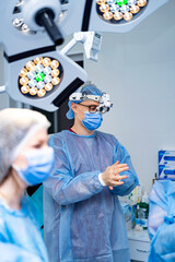 Surgery prep in OR. Surgeons prepare for a procedure in a sterile operating room, discussing...
