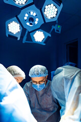 Surgical team focused during operation. Medical professionals in surgical attire work diligently...