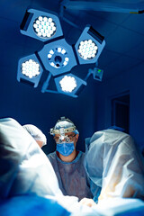 Surgeons operate in bright room. Two surgeons are carefully engaged in a surgical procedure,...