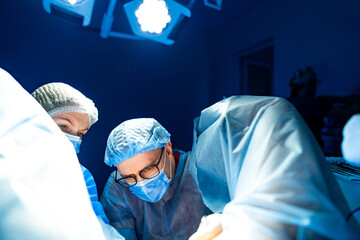 Surgeons performing a delicate operation. Two surgeons focus intently on a surgical procedure in a...