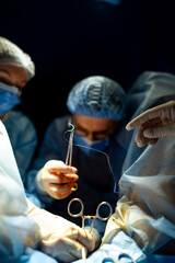 Surgeons operate in the OR. Medical professionals conduct a surgical operation while focused on...