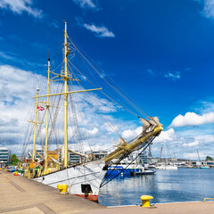 Deck of the sailing ship moored at the sunny pier. Summer voyage	