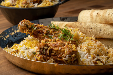 Spicy chicken biryani in pot. served with onion raita	