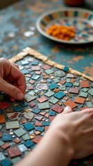 Naklejka premium Hands creating colorful mosaic art with ceramic tiles