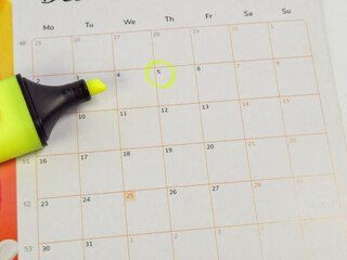 Calendar with a yellow highlighter marking the important date of the fifth