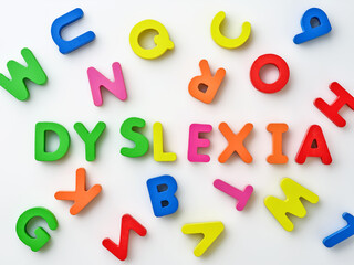 Dyslexia word bright colorful wooden toy blocks in white background. Dyslexia concept. difficulty with fast reading, writing words, education learning elementary school kids.