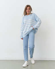 Charming female model showcasing cozy fashion in a bright studio setting